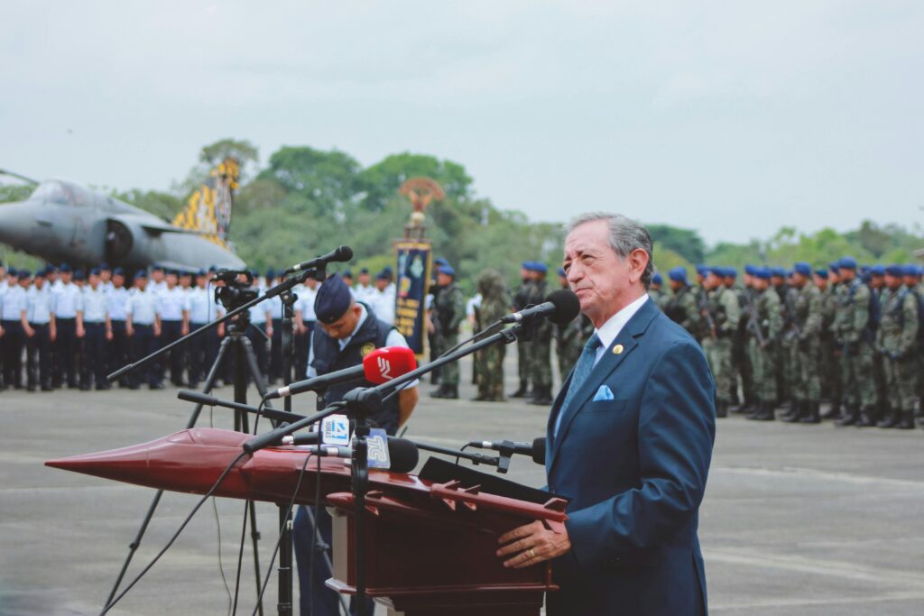 pexels photo 3880204 3880204 Side view of mature colonel with order standing near microphones on asphalt pavement behind army of soldiers near airplane monument under serene sky during national military holiday and looking away