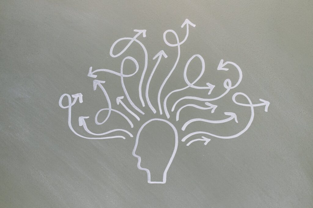 Conceptual chalk drawing illustrating mental health challenges with arrows representing thoughts.